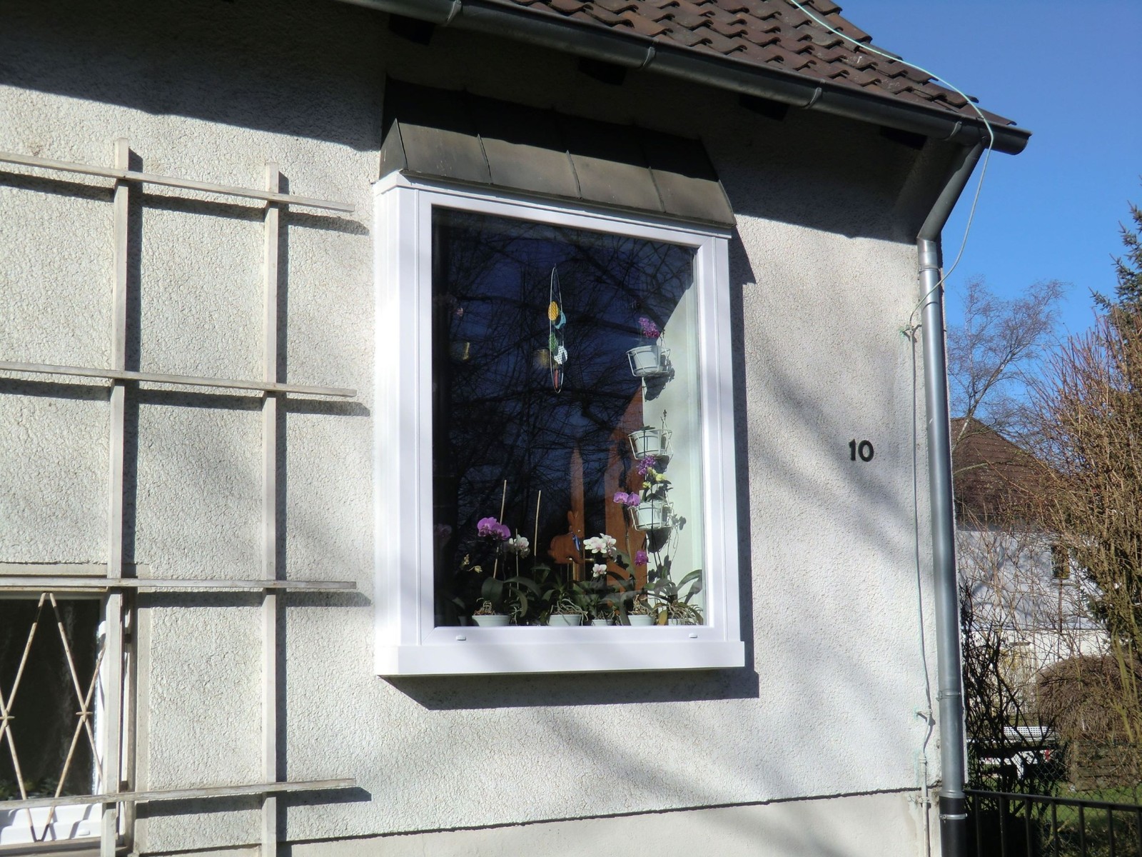Neu montiertes weißes Fenster an einer verputzten Hausfassade