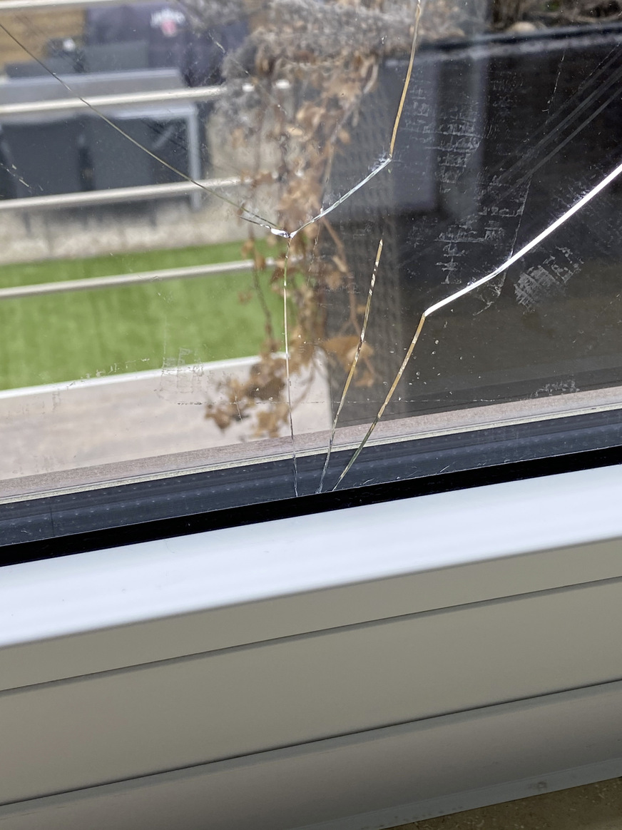 Defekte Fensterscheibe mit deutlich sichtbaren Rissen